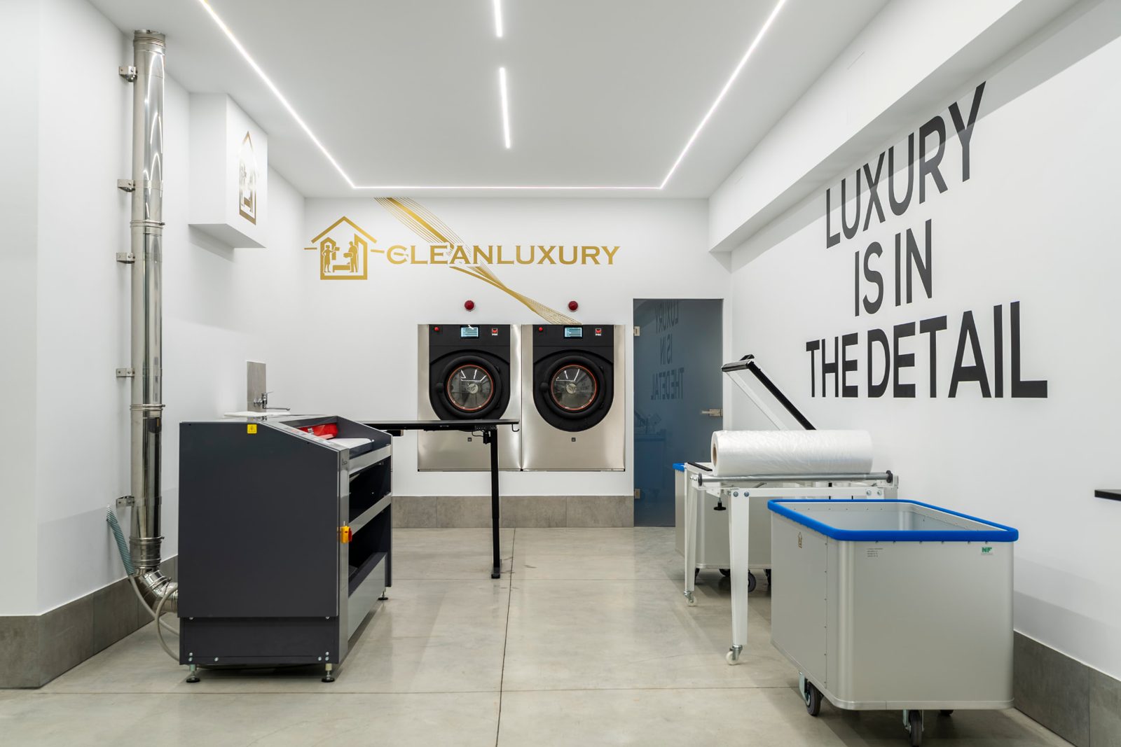 Laboratorio Clean Luxury Group: lavatrici professionali, carrelli e postazione di confezionamento della biancheria